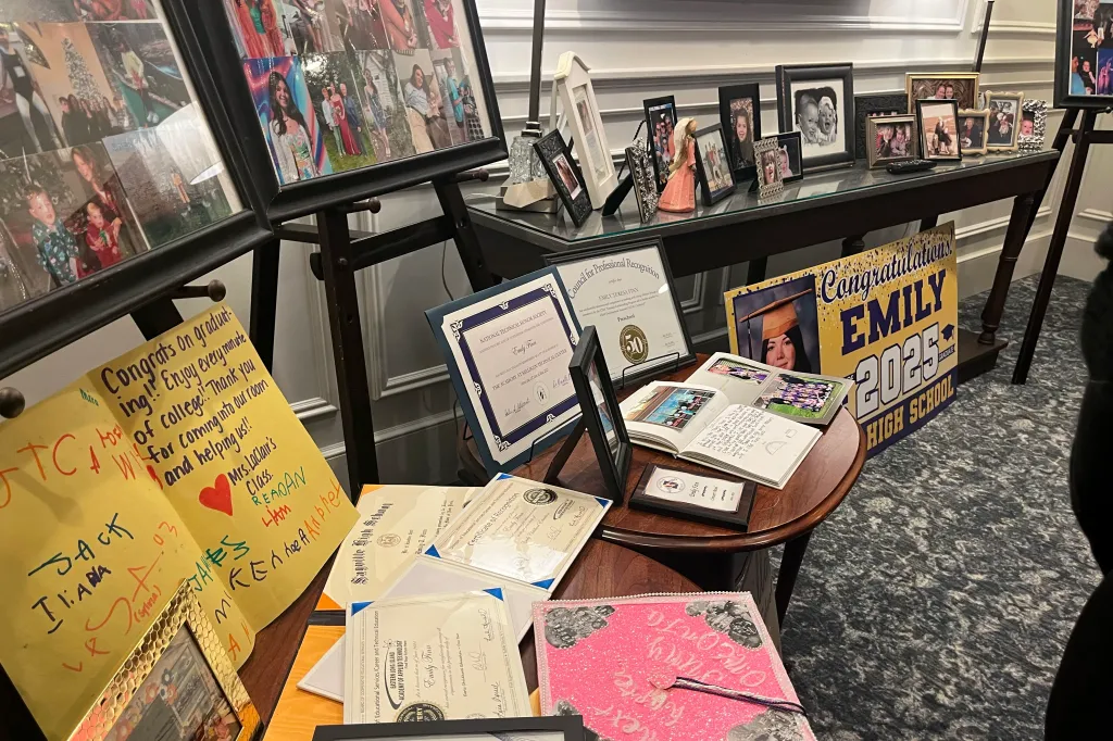 Items on display for Emily Finn's wake/funeral including photos, certificates, and a graduation sign.