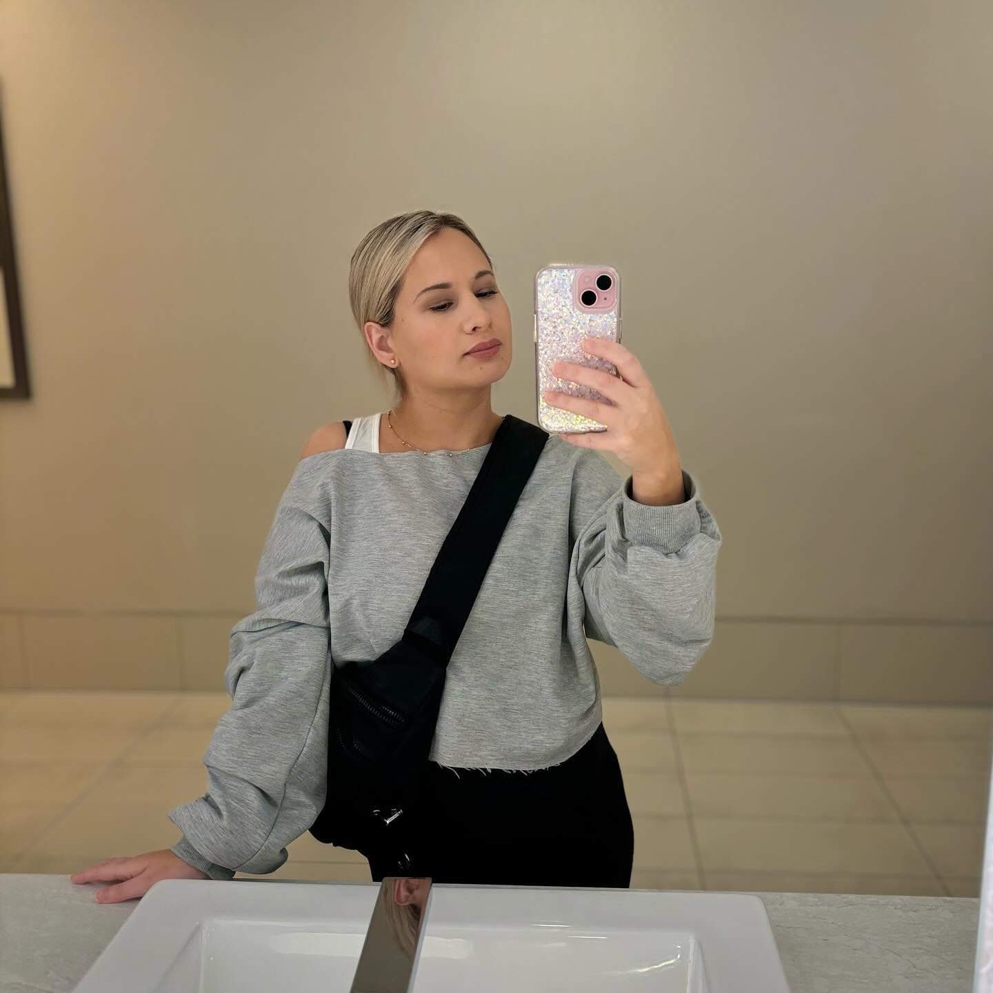 Gypsy Rose Blanchard takes a mirror selfie in a bathroom, holding her phone with a sparkly case.