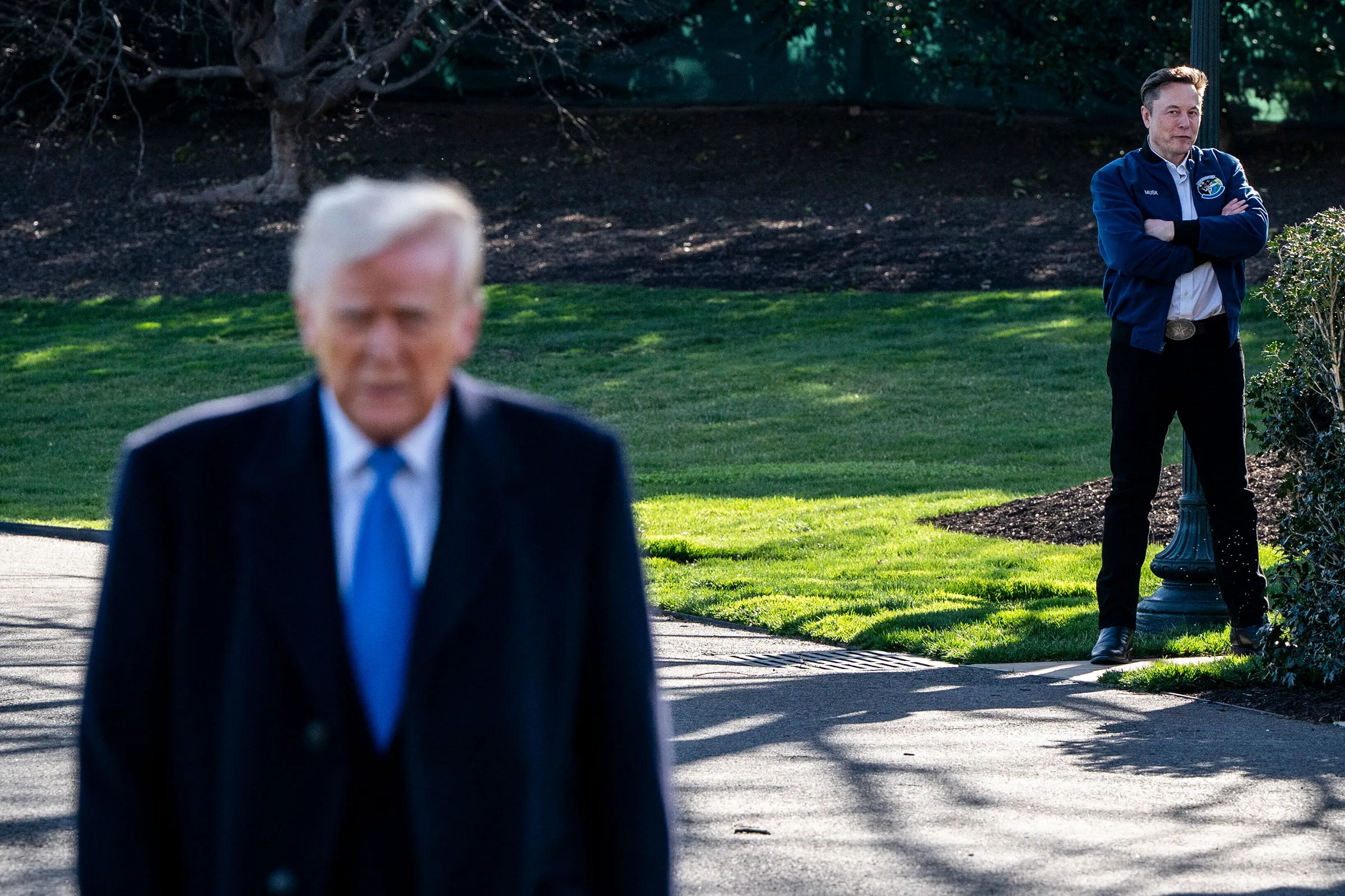 Elon Musk watches as President Donald Trump speaks to reporters outside the White House in Washington, March 21, 2025. (Haiyun Jiang/The New York Times)