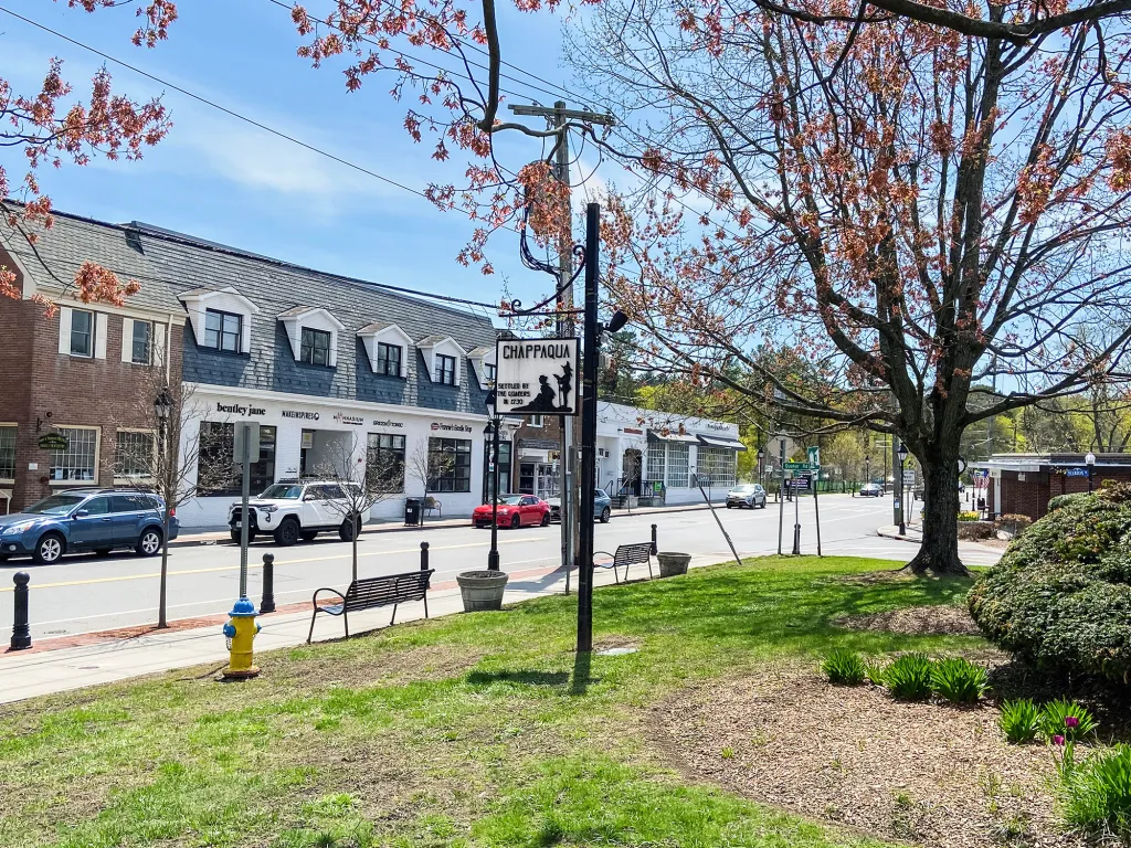 View of downtown shops in Chappaqua, New York, with a commemorative plaque stating