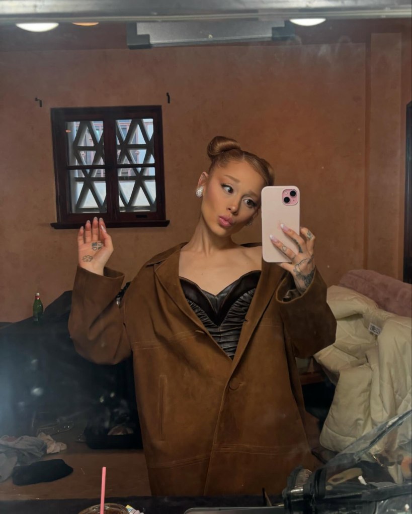 Ariana Grande taking a mirror selfie, pouting her lips.