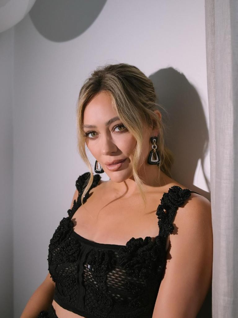 Hilary Duff in a black top and statement earrings.
