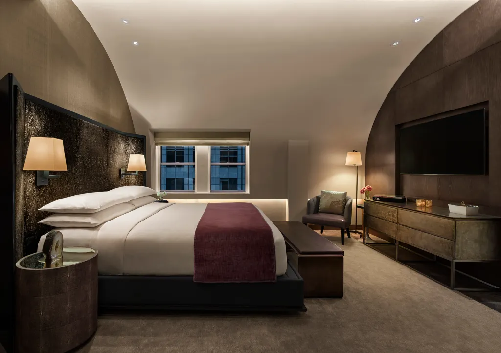 Bedroom with a king-sized bed, two windows, and a TV at Knickerbocker Hotel