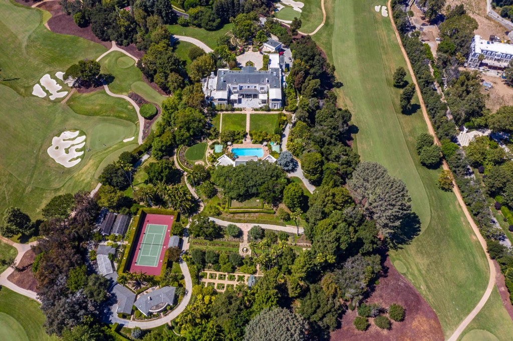 Aerial view of the 1930s Bel-Air estate at 10644 Bellagio Rd, showing the 60-room mansion, grounds with a swimming pool, tennis court, and surrounding golf course.