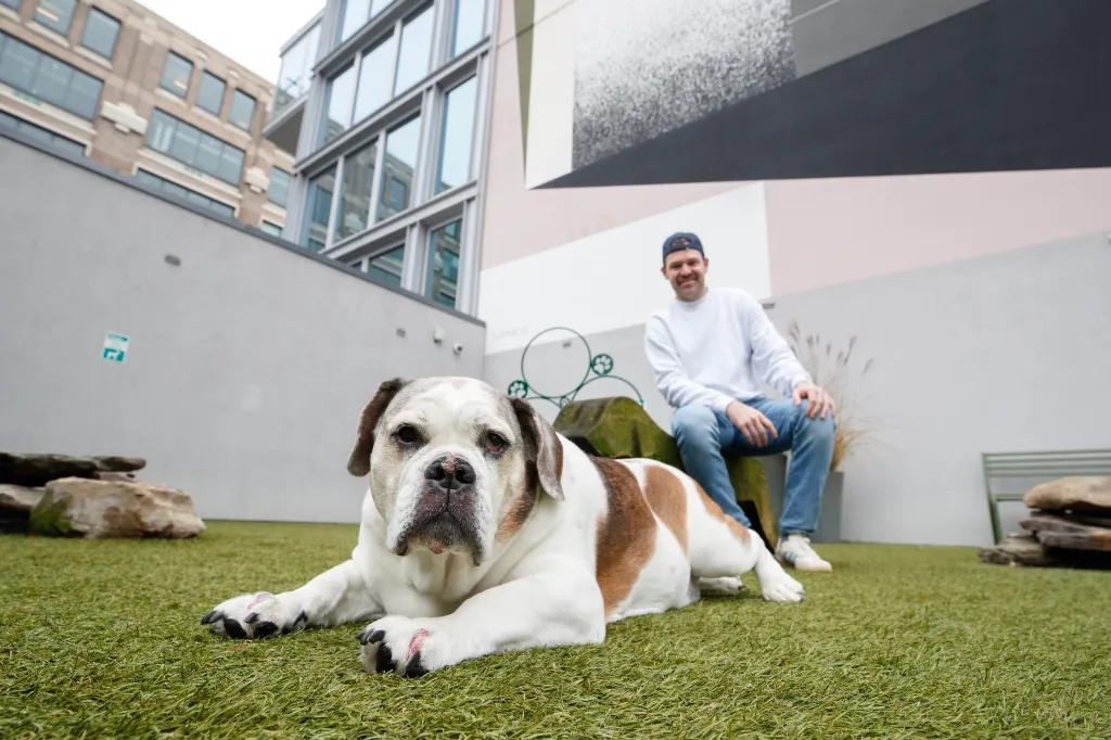 Chris DiStefano with his dog Ripley in a dog run on the 8th floor of his apartment building.