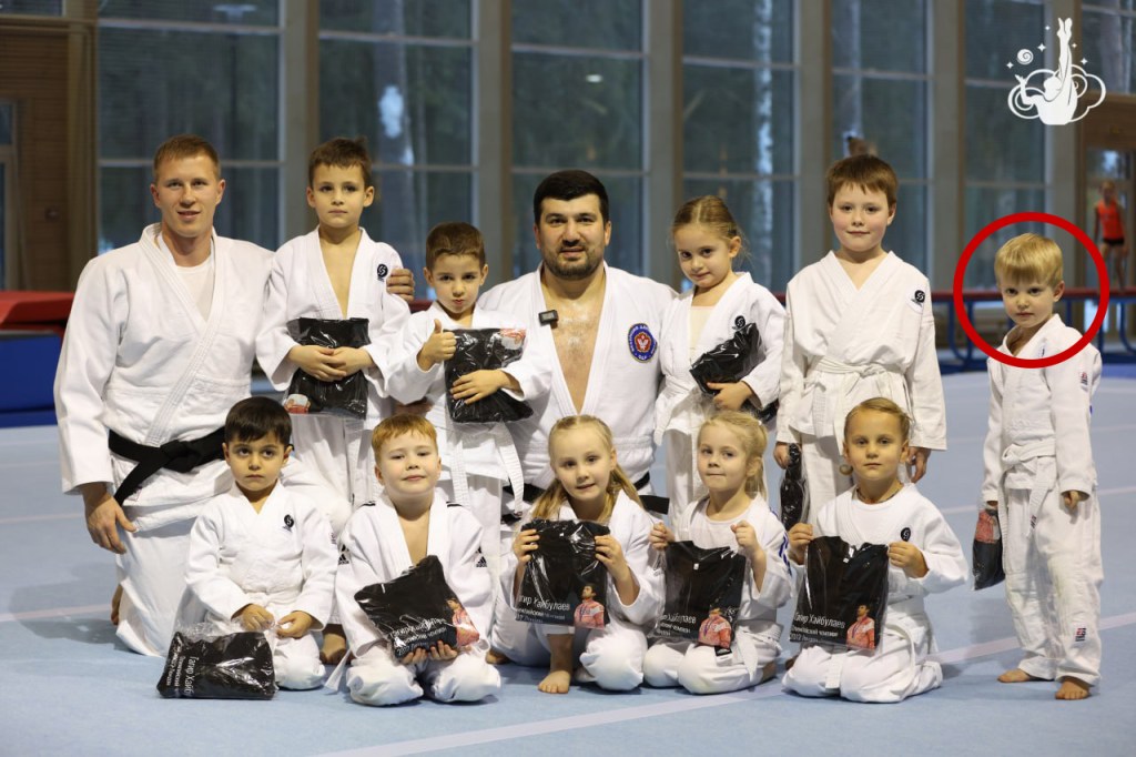 Group photo of martial arts students and instructors at a sports camp.