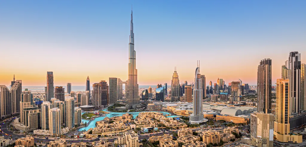 Dubai downtown cityscape with the Burj Khalifa and many other skyscrapers at sunset.