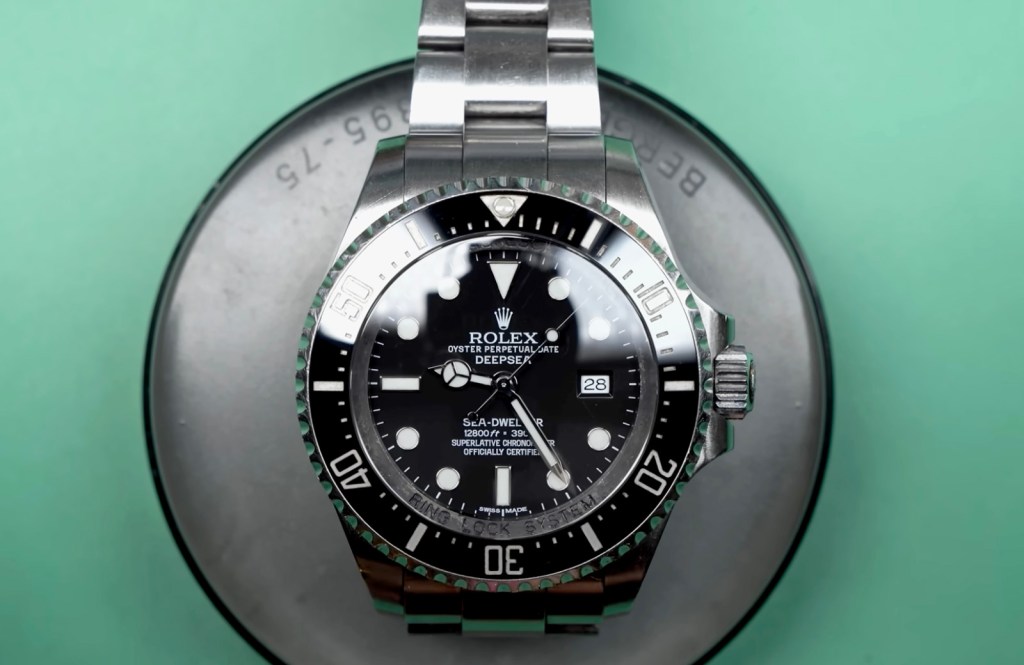 A Rolex Oyster Perpetual Date Deepsea Sea-Dweller watch with a black face and metal band.