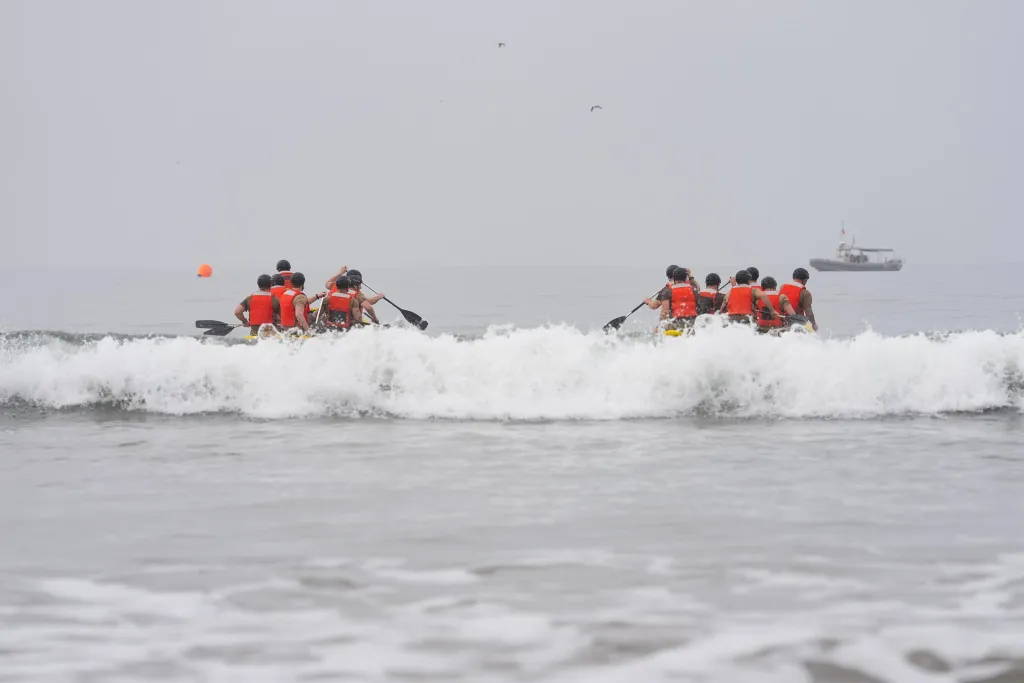 JD Vance training with Navy SEALs in California, paddling in two groups on small boats through ocean waves.