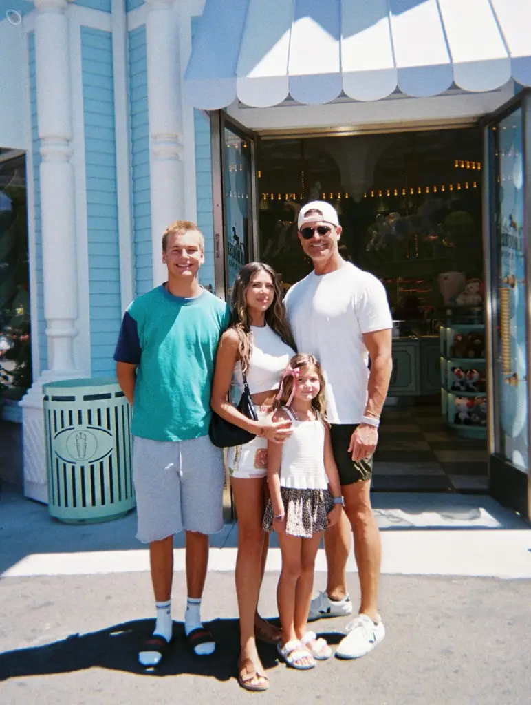 Demi and Bret Engemann with their two kids in front of a carousel shop.