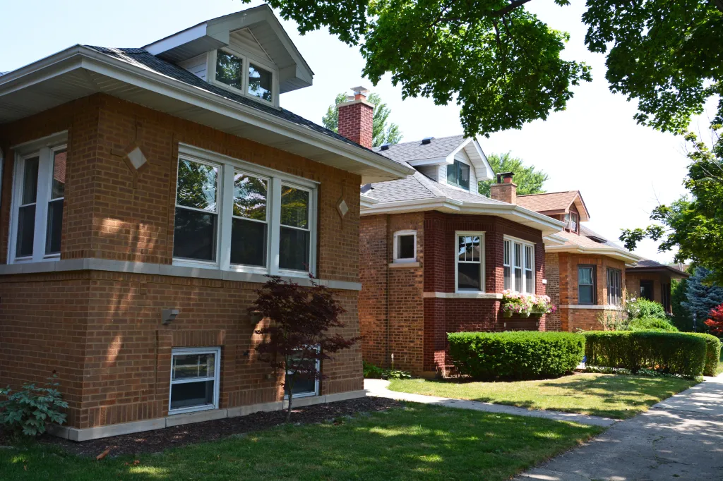 Row of brick Chicago bungalows on a tree-lined street.