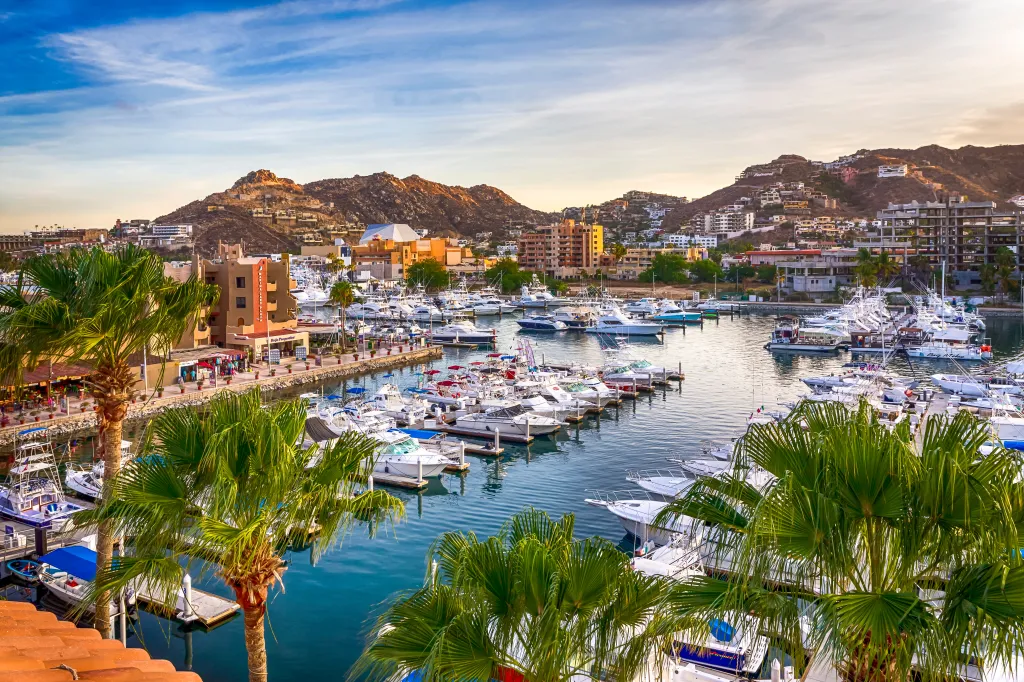 Wide view of the ocean bay and docks filled with pleasure vessels in Cabo San Lucas, Baja California, Mexico.