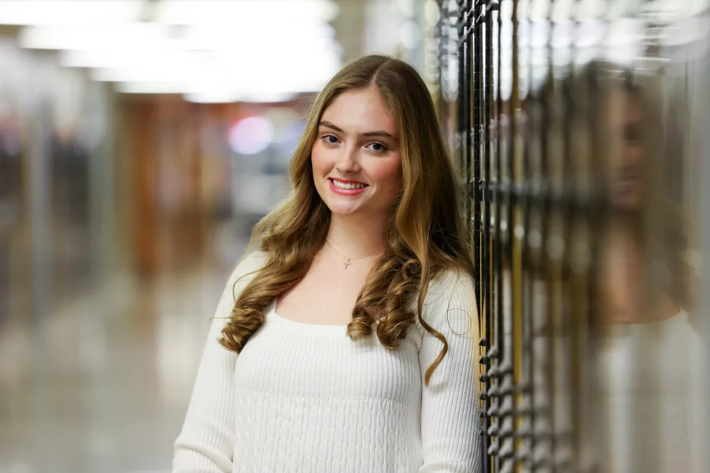 Alyssa Tappin, a senior at Sachem North HS and aspiring sports broadcaster, smiling while leaning against lockers.