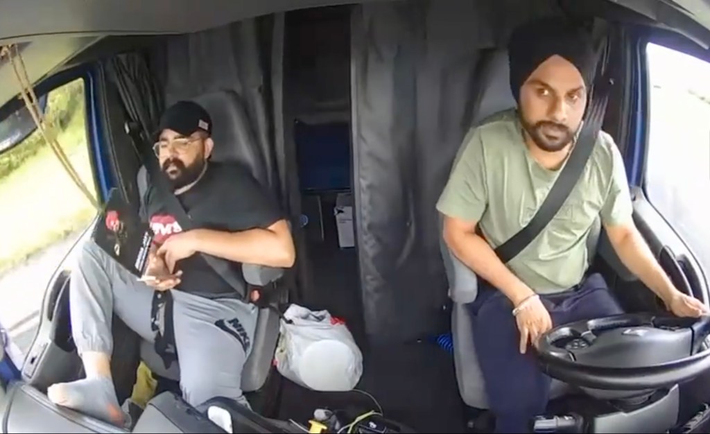 Harjinder Singh driving a semi-truck with a passenger.