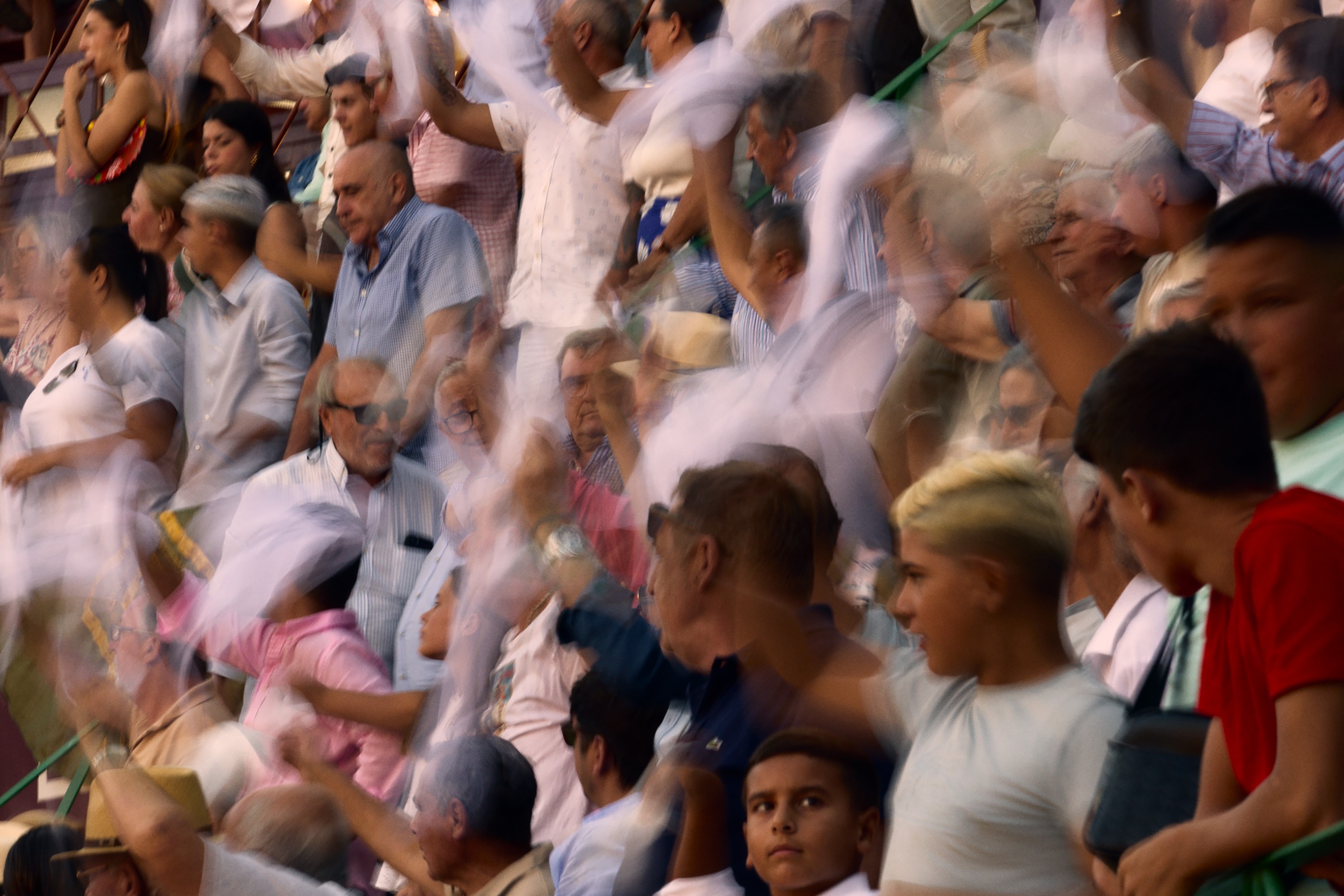 photo of crowded audience at bullfight, many waving white cloths