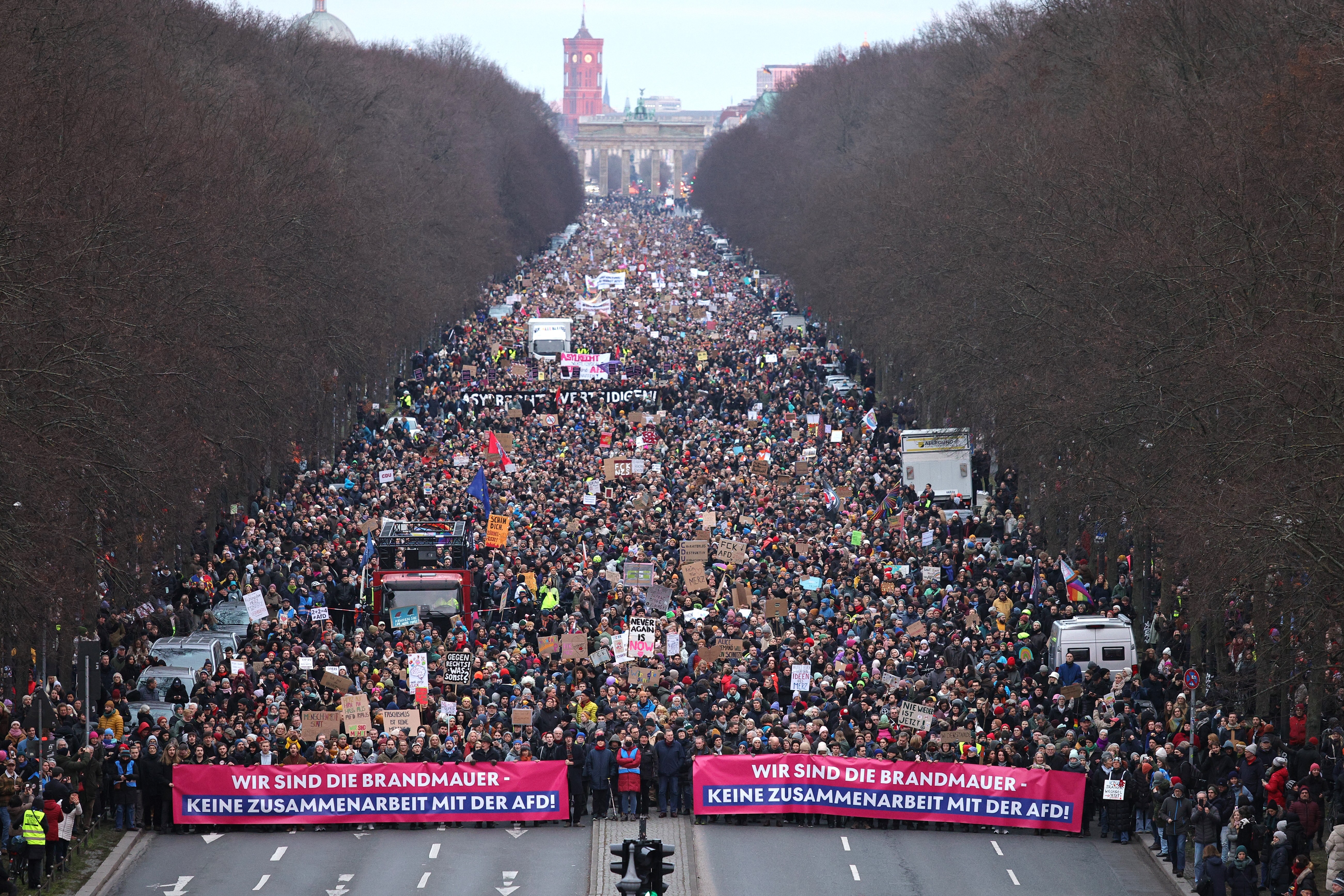 A large crowd of protesters march in Berlin, carrying banners that, translated from German, read, “We are the firewall. No cooperation with the AfD.”