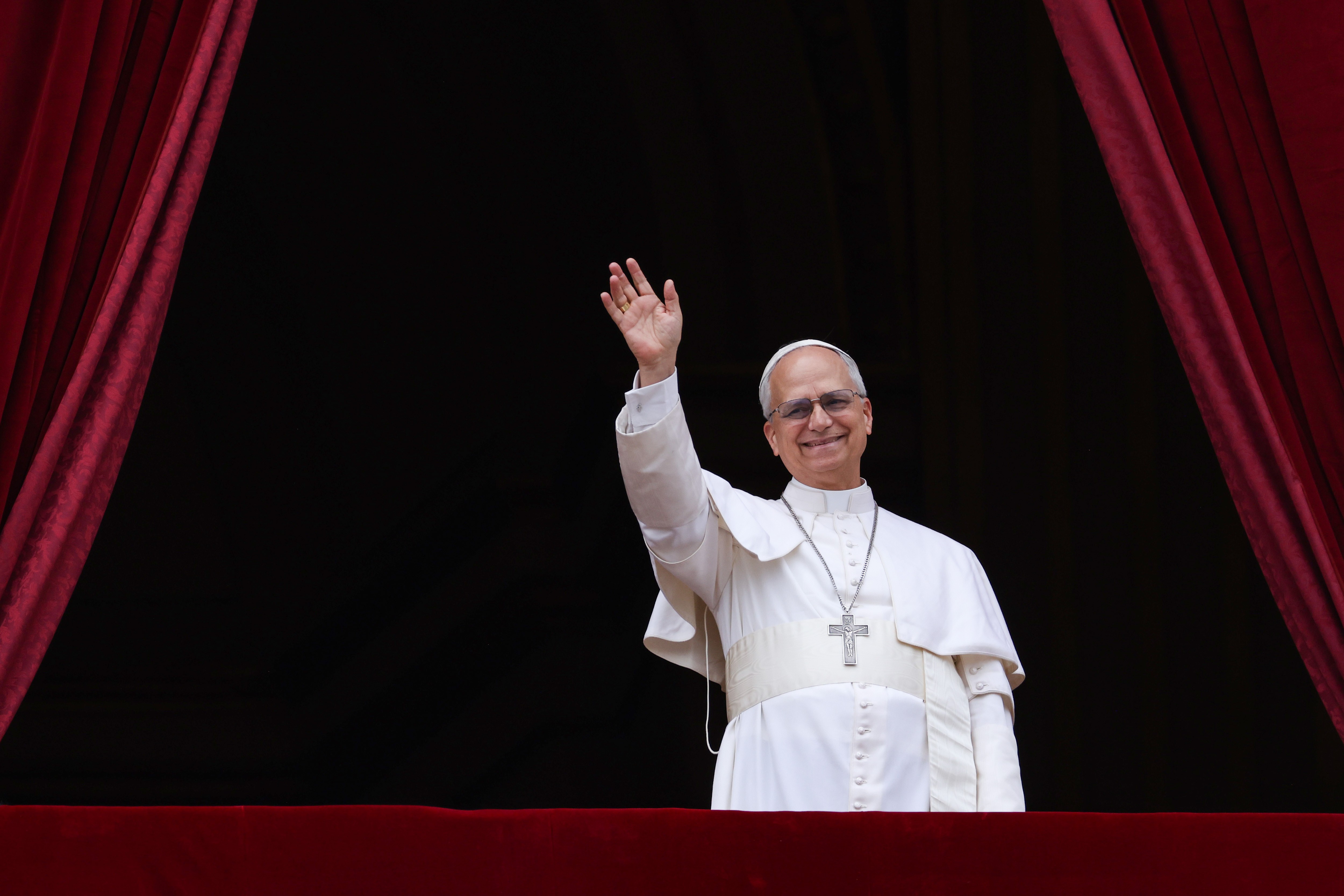 Pope Leo waves from a balcony.