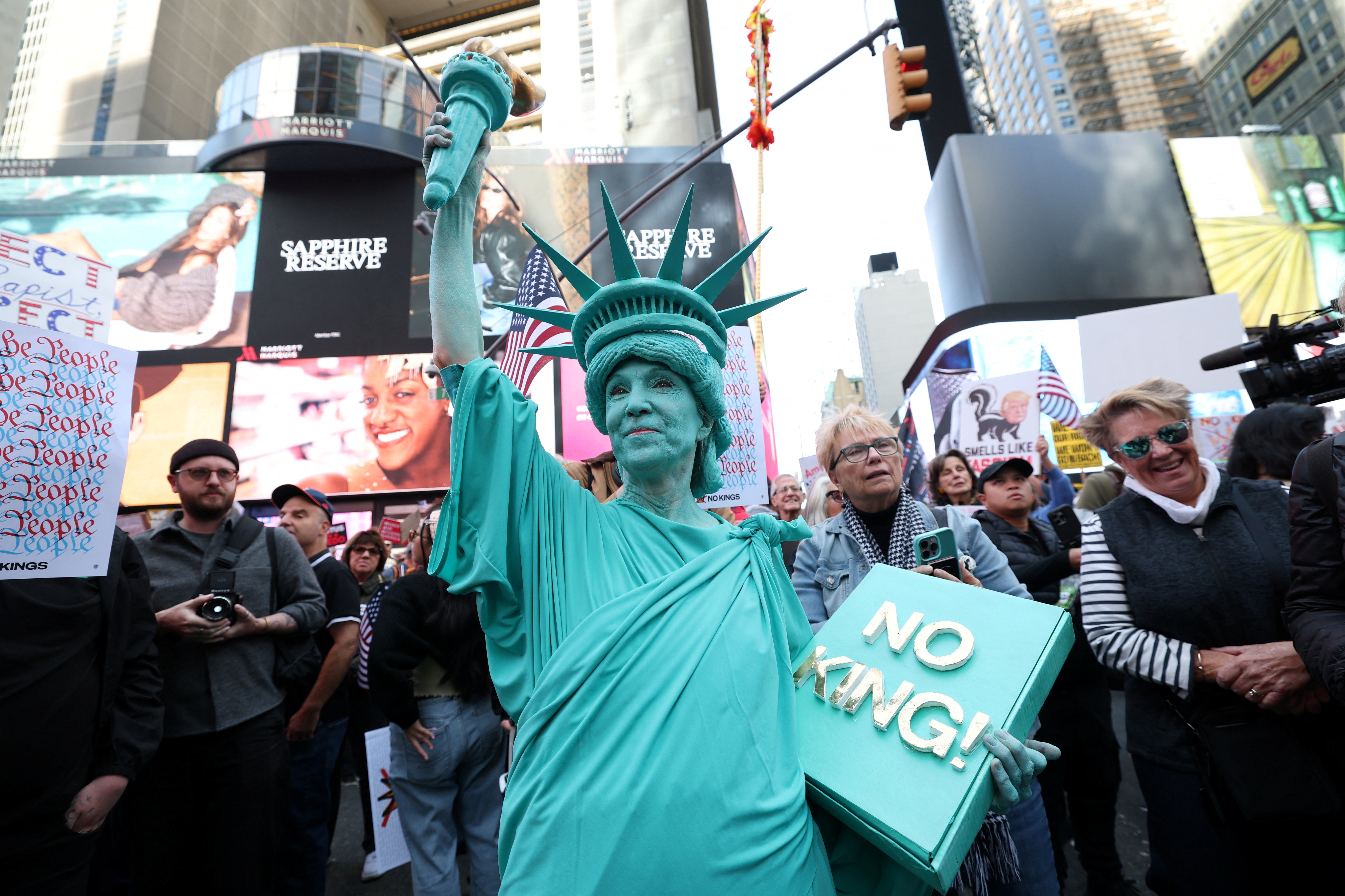 A person dressed in a Statue of Liberty costume participates in a No Kings protest.