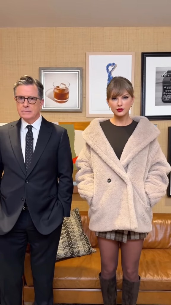Stephen Colbert in a black suit with Taylor Swift in a cream coat and plaid skirt.