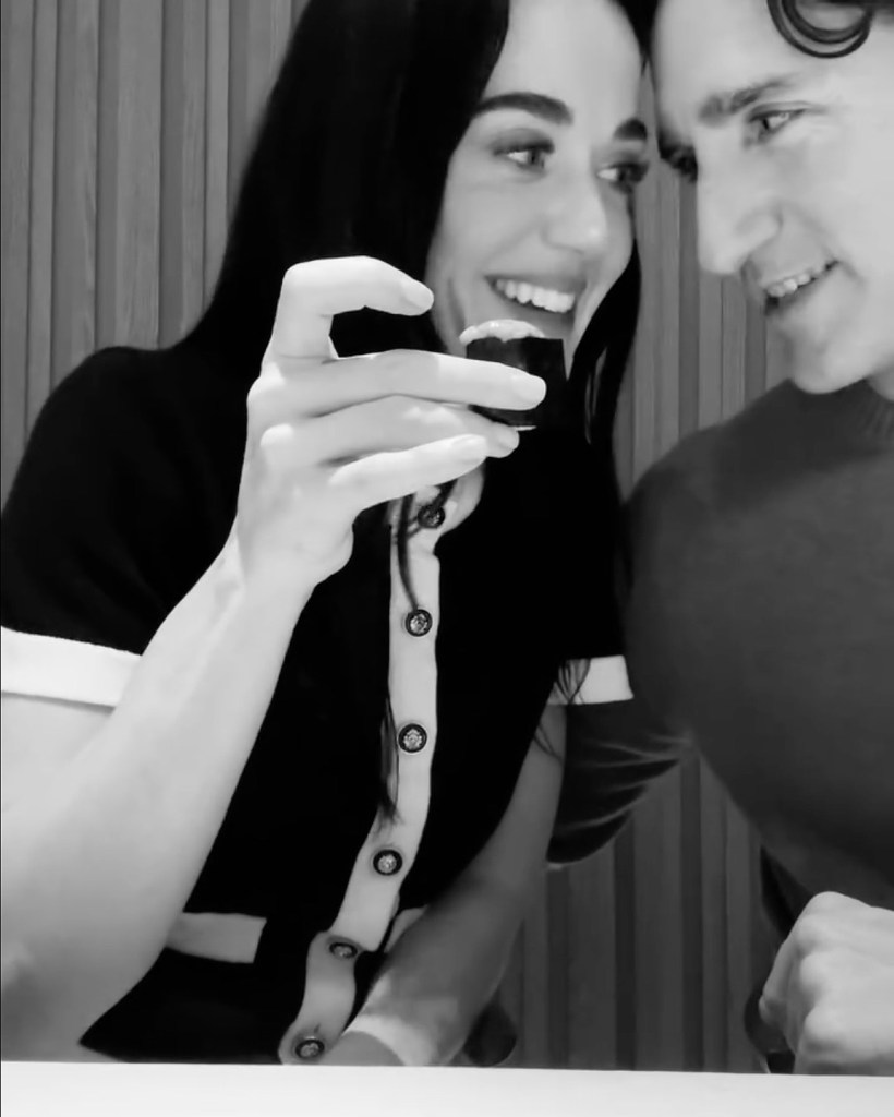 Katy Perry holding up sushi to Justin Trudeau in Tokyo.