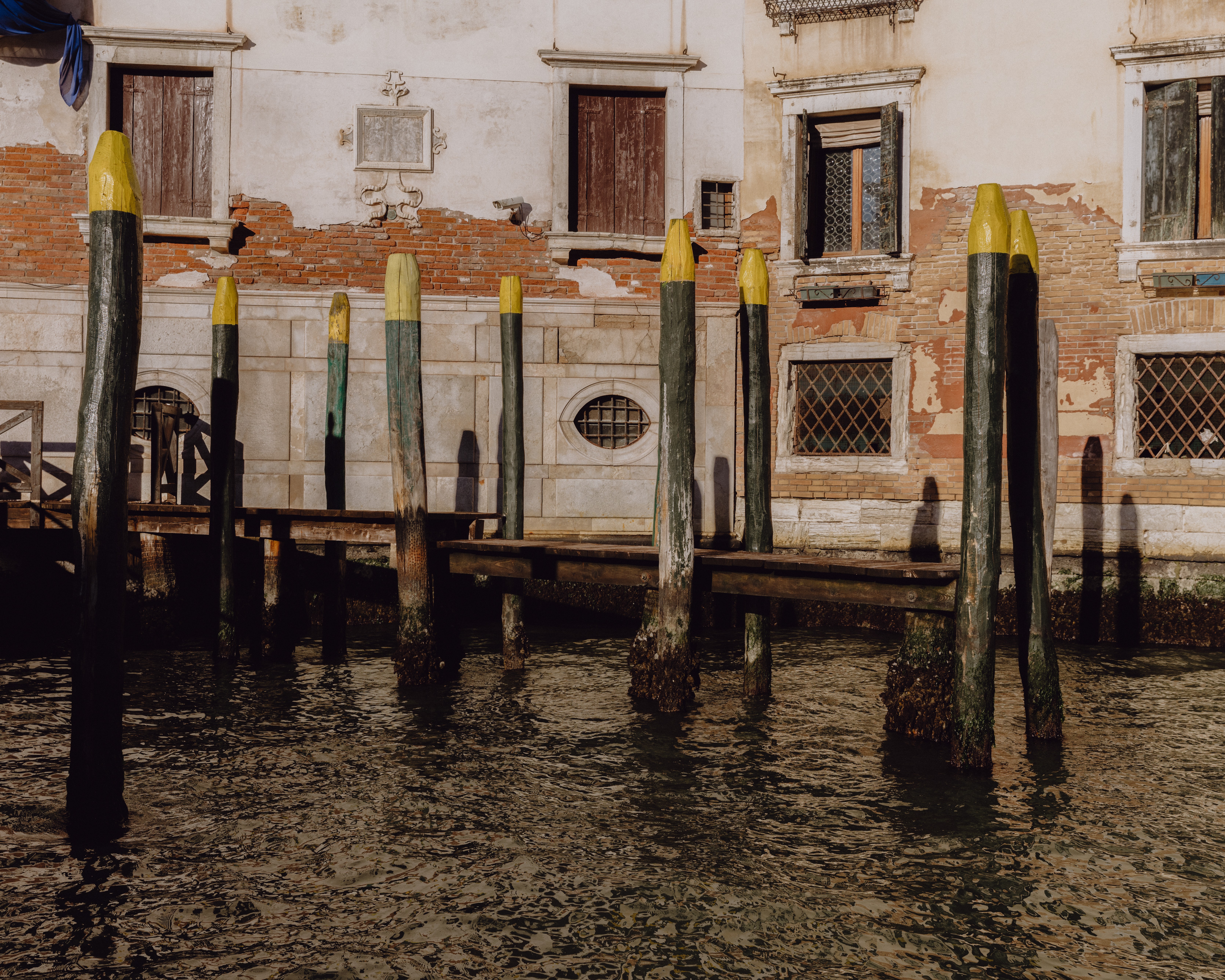 Boat poles for parking boats in the Venice canal marked with yellow paint