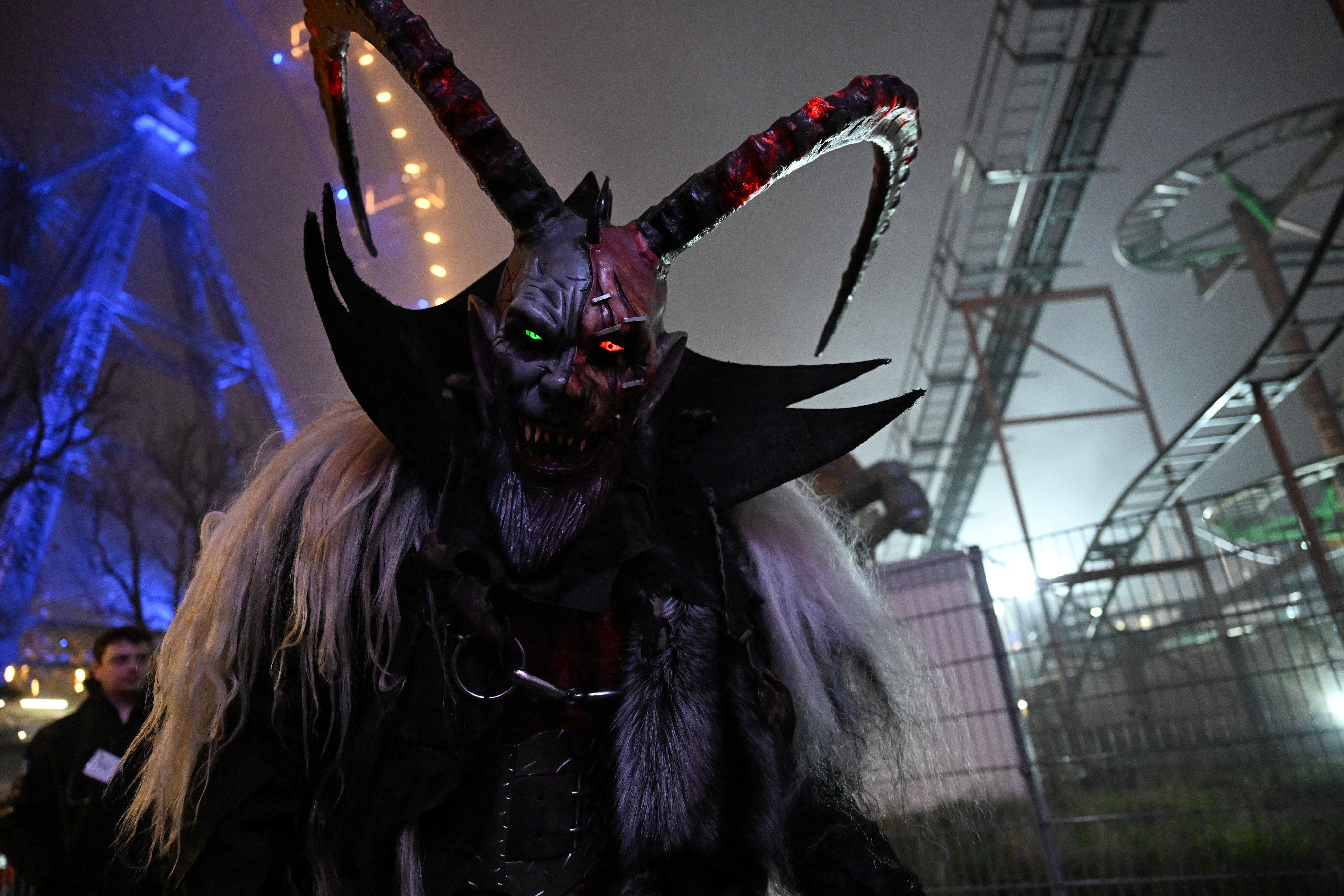 A close view of a person wearing a scary Krampus costume and mask with long curved horns.