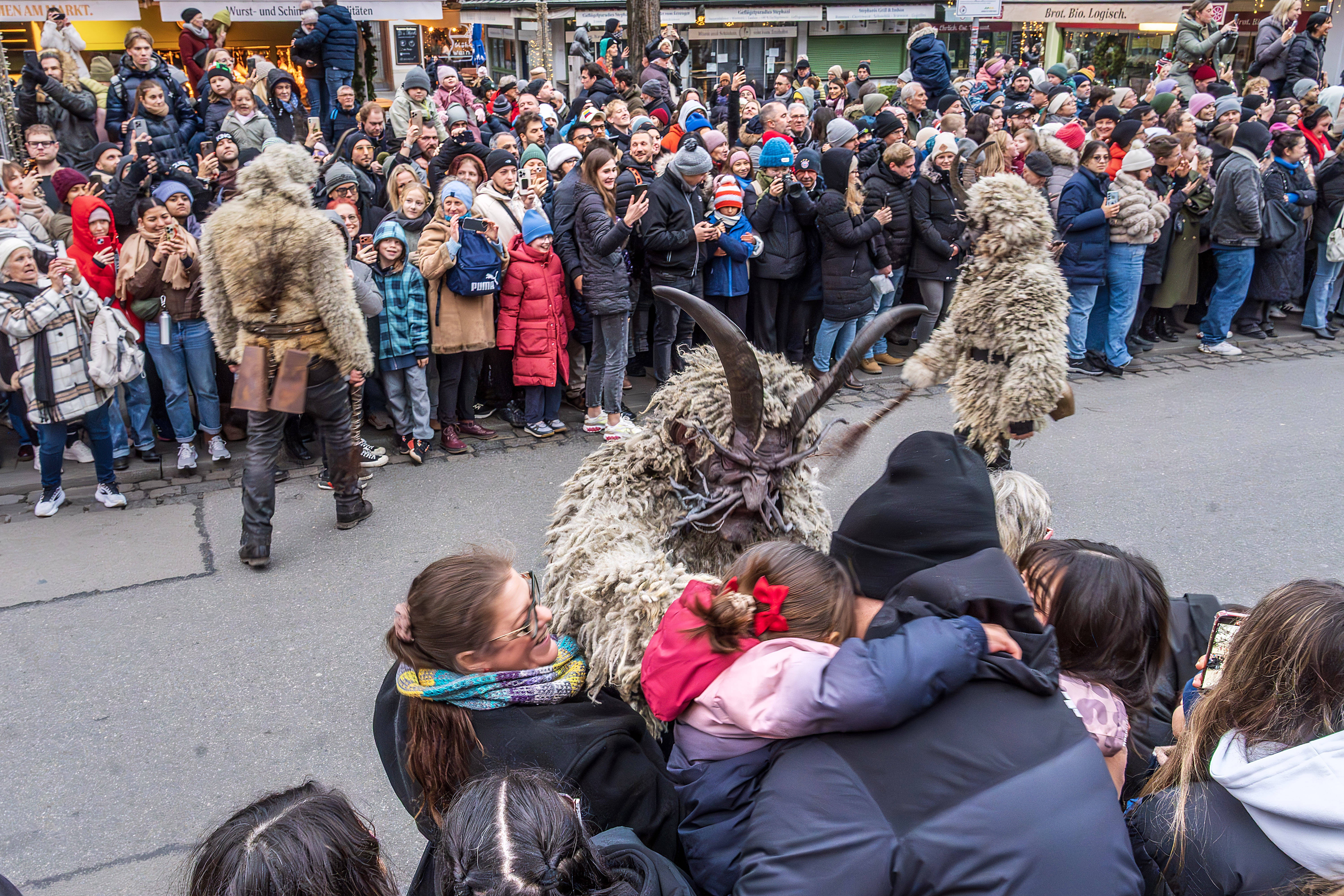 Onlookers watch as performers take part in a Krampus run in Munich.