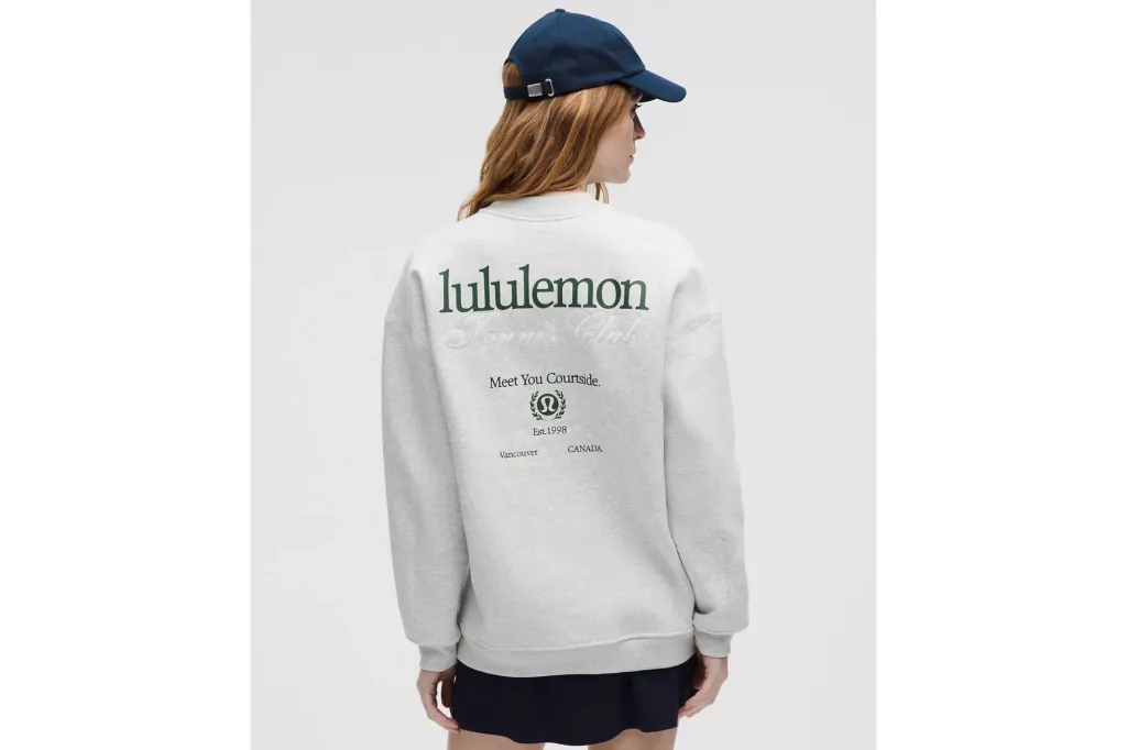 A woman in a grey sweatshirt, wearing a hat.