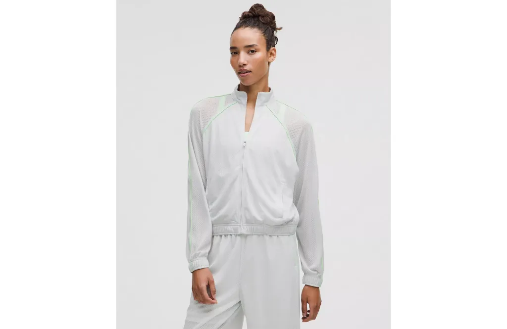 Woman wearing a light gray zip-up jacket and matching pants.