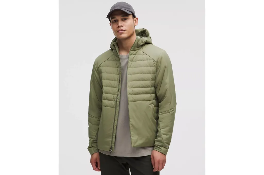 A man in a lightweight jacket, wearing a hat.