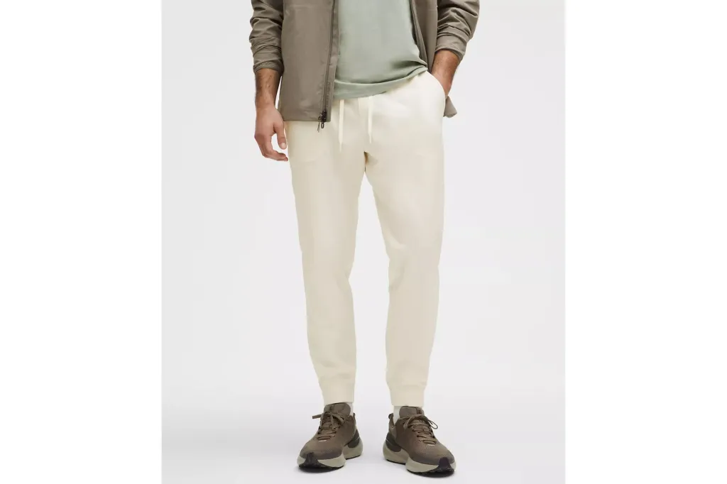 A man wearing white joggers and a jacket.