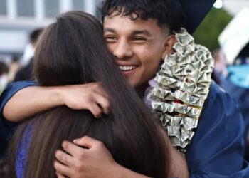 Every year, a billionaire CEO doles out $1,000 checks to local college grads—with a catch: They have to give half the money to charity