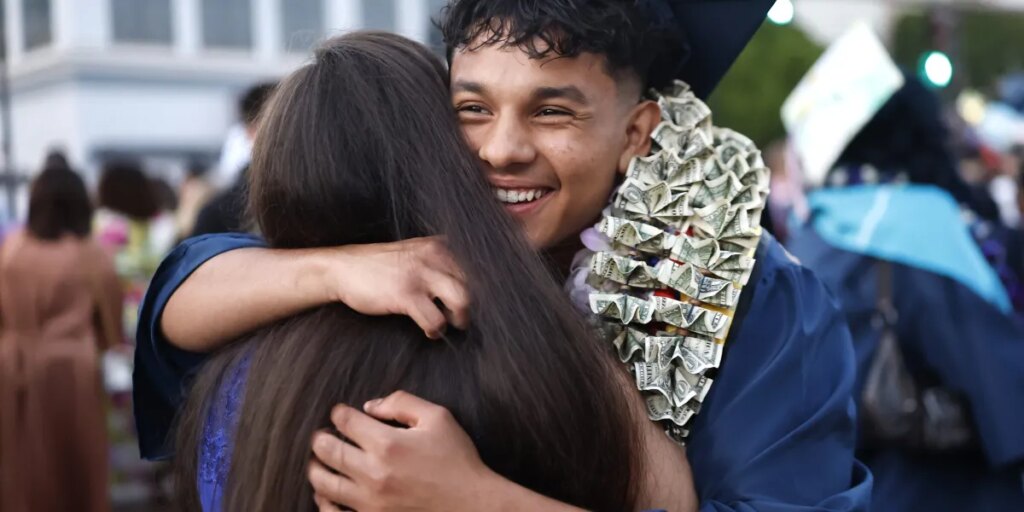 Every year, a billionaire CEO doles out $1,000 checks to local college grads—with a catch: They have to give half the money to charity