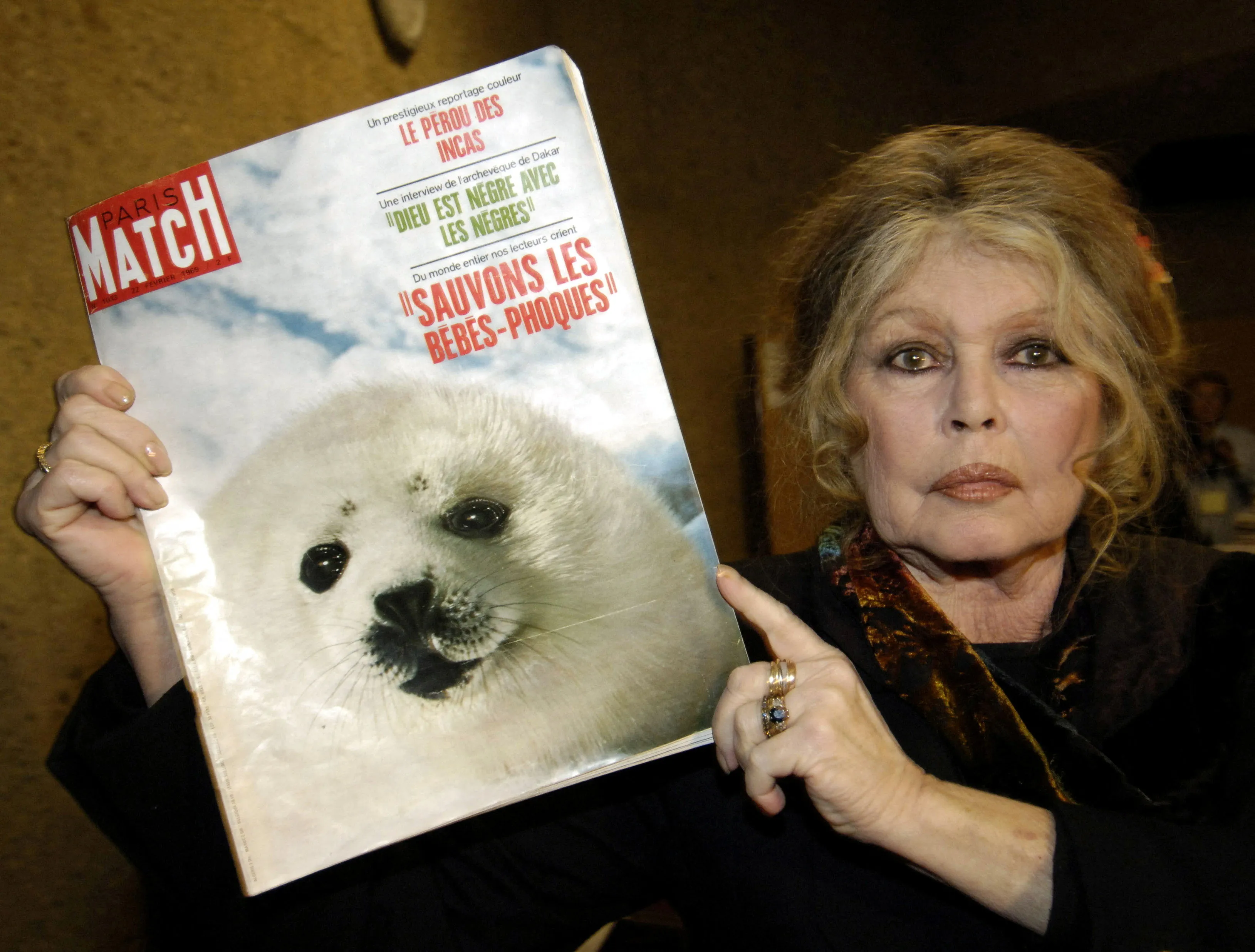 Former French actress Brigitte Bardot displays a 1969 copy of French magazine 
