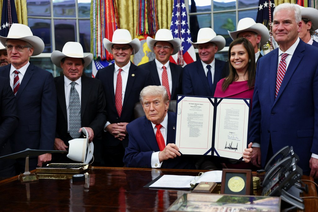 U.S. President Donald Trump signs a bill to award congressional gold medals to members of the 1980 U.S. Olympic men's hockey team in the Oval Office.