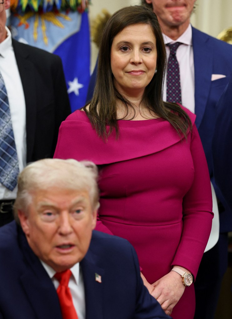Rep. Elise Stefanik looks on as President Donald Trump signs a bill.