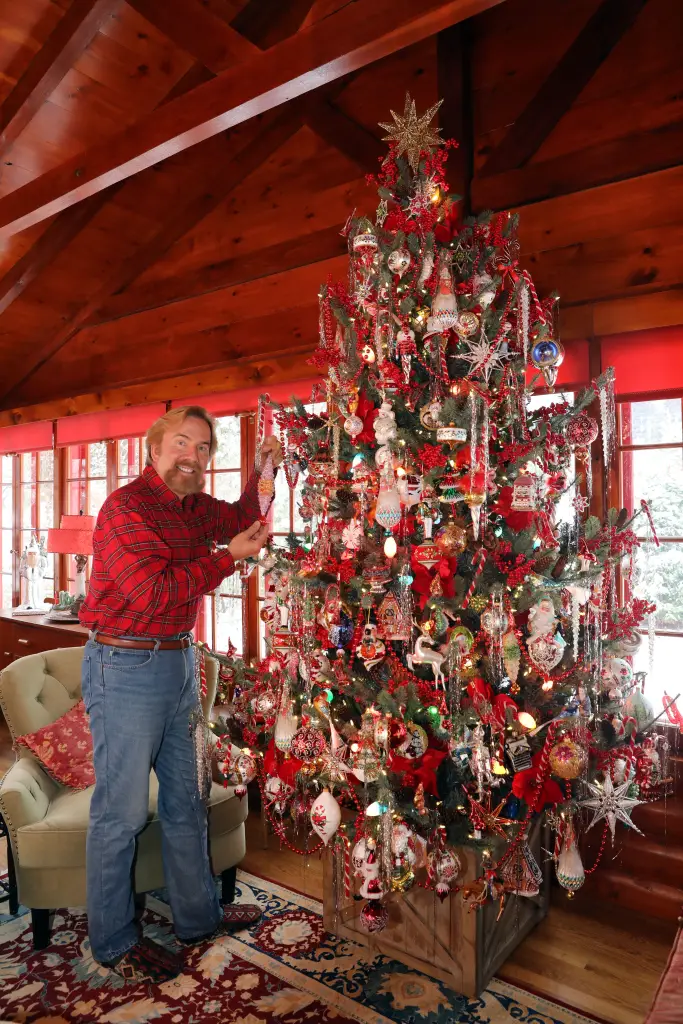 Christopher Radko places an ornament on his Christmas tree, which is filled with his ornament collection.
