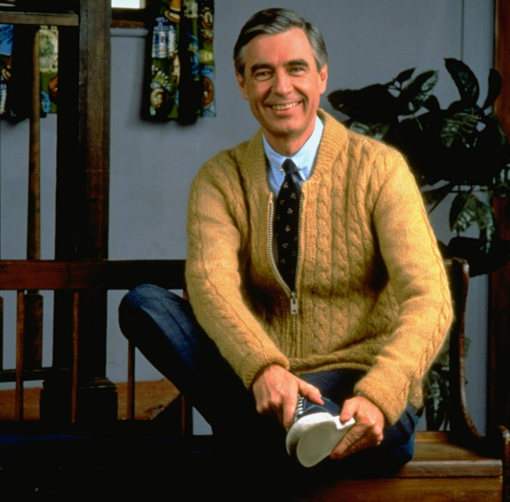 Fred Rogers changing into sneakers, while wearing his iconic yellow cardigan, on the set of Mister Rogers' Neighborhood.