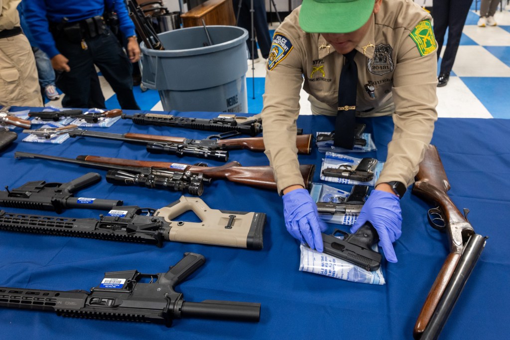 New York City Police Department personnel display guns collected at a buyback event.