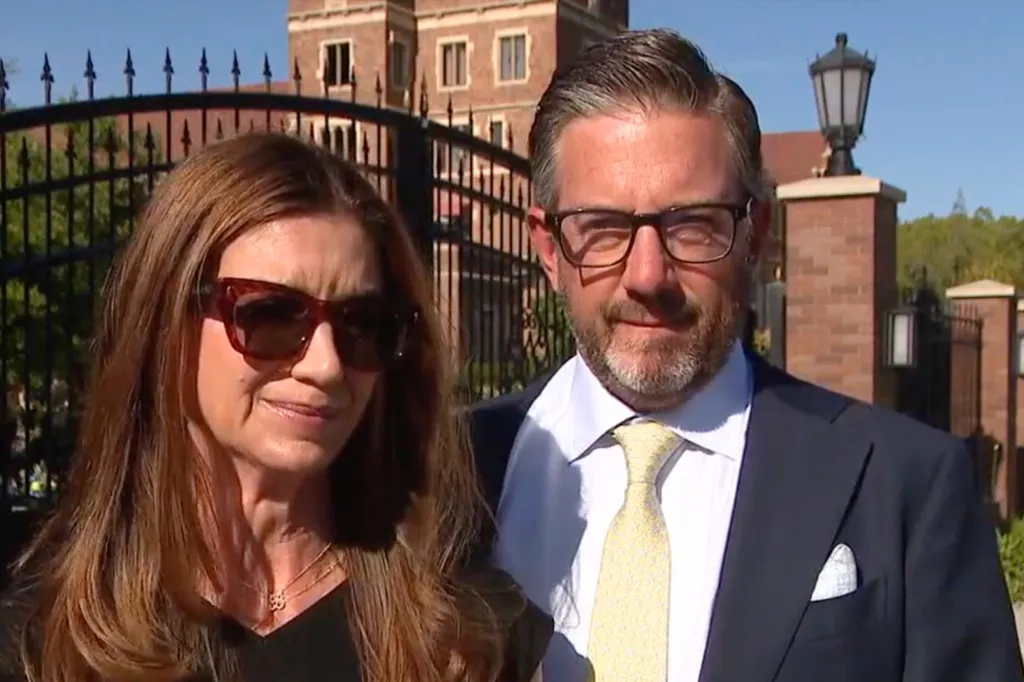 Braun Levi's parents, Jennifer Levi and her husband, against a backdrop of a brick building.