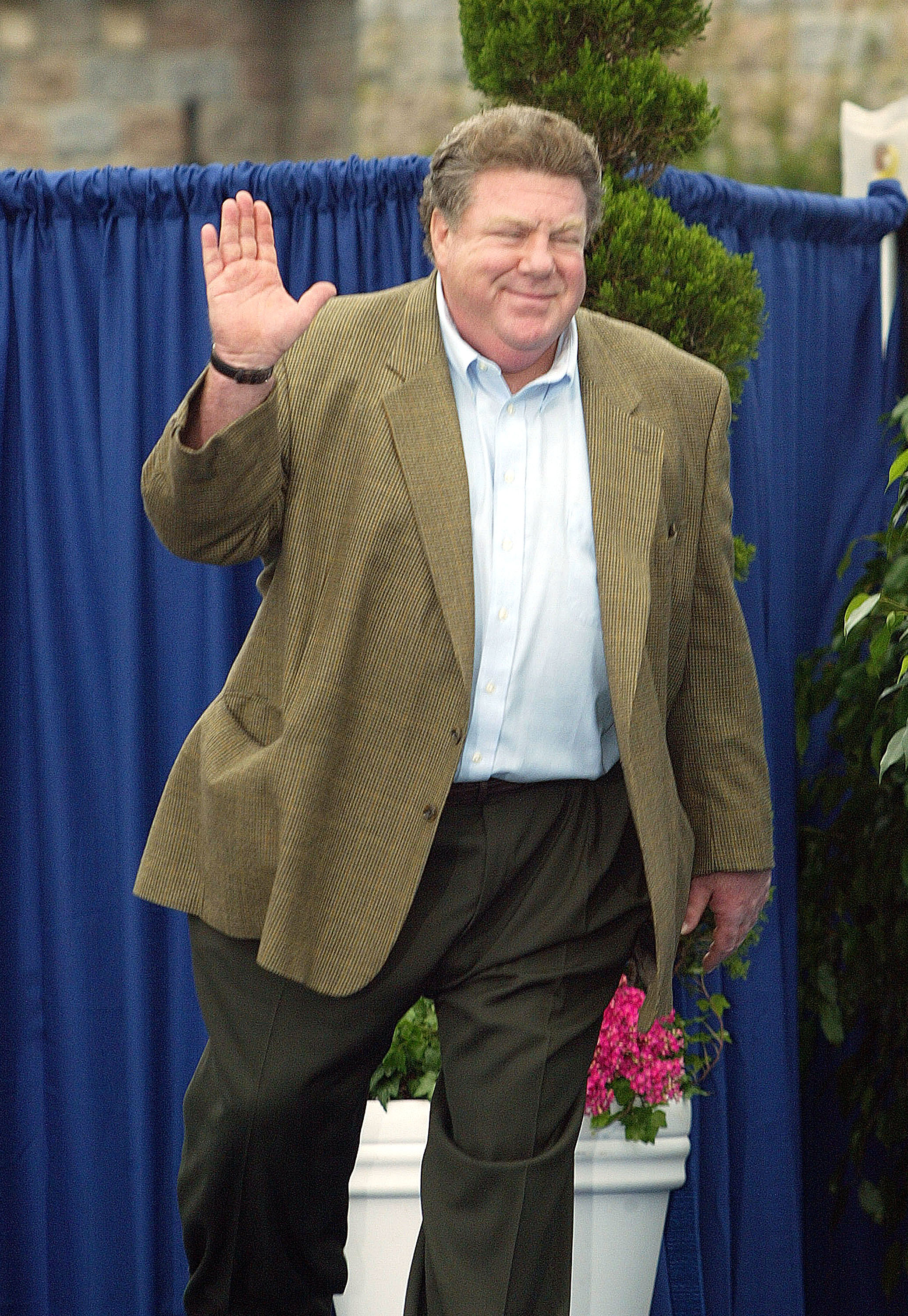 George Wendt waves in a sport jacket.