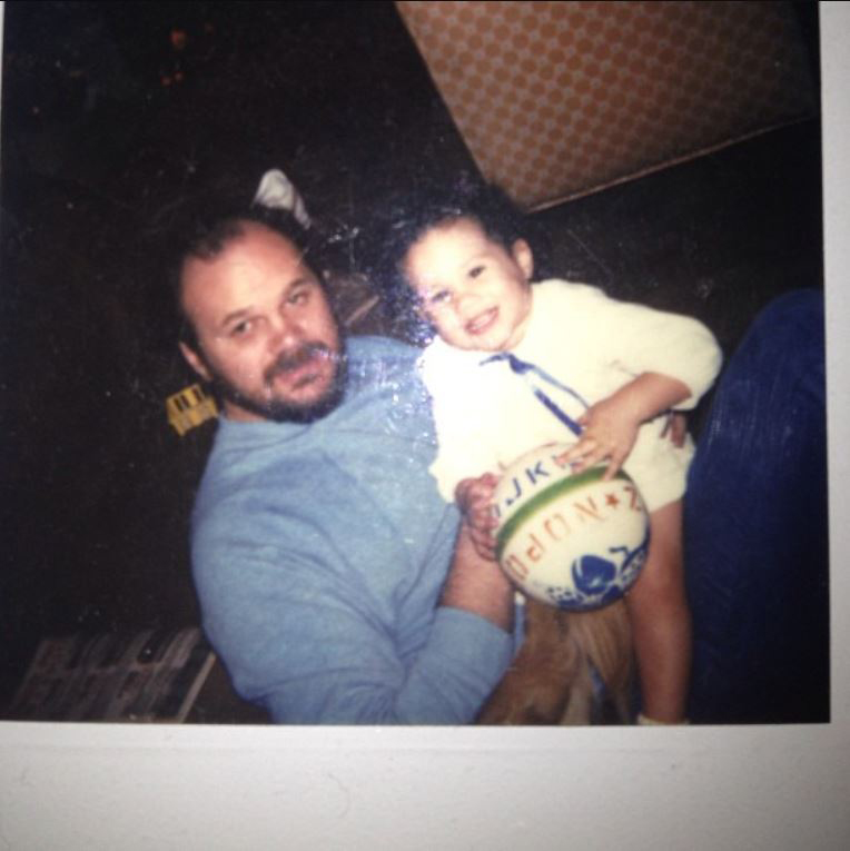 Meghan Markle as a baby held by her father Thomas Markle, holding a ball.