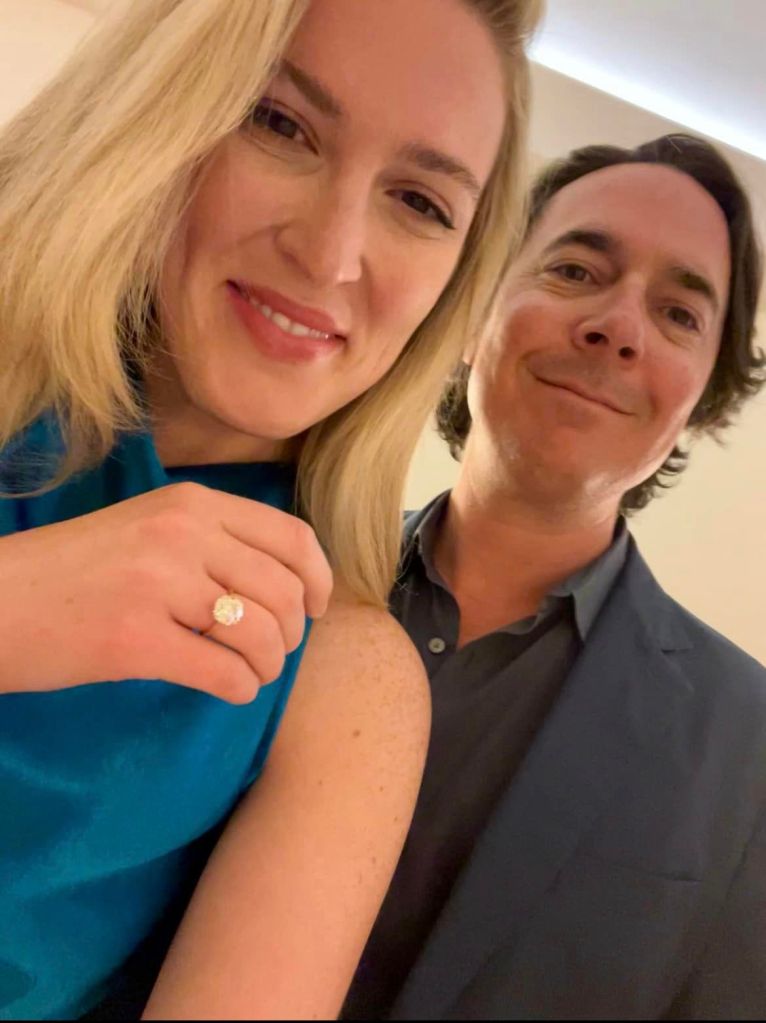Olivia Nuzzi showing an engagement ring on her finger next to Ryan Lizza.