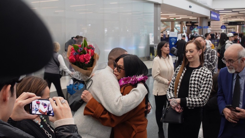 Jen Shah hugs her husband at Salt Lake City International Airport.