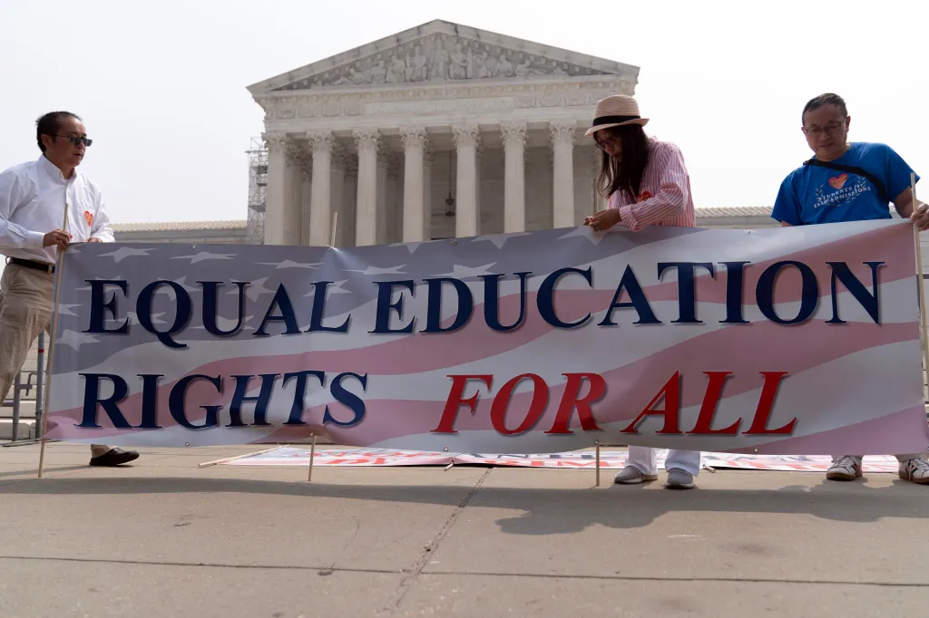 Protesters hold a banner reading 