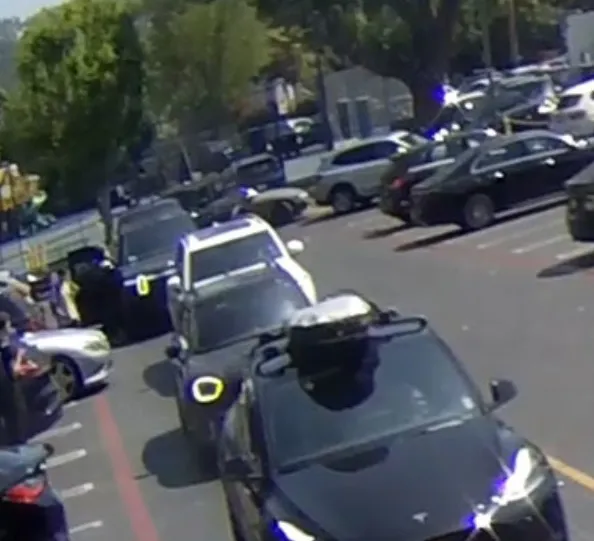 Security footage of cars in a parking lot.