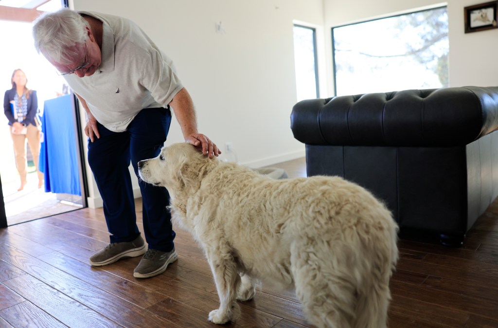 Ted Koerner pets his dog Daisy May in their new home.