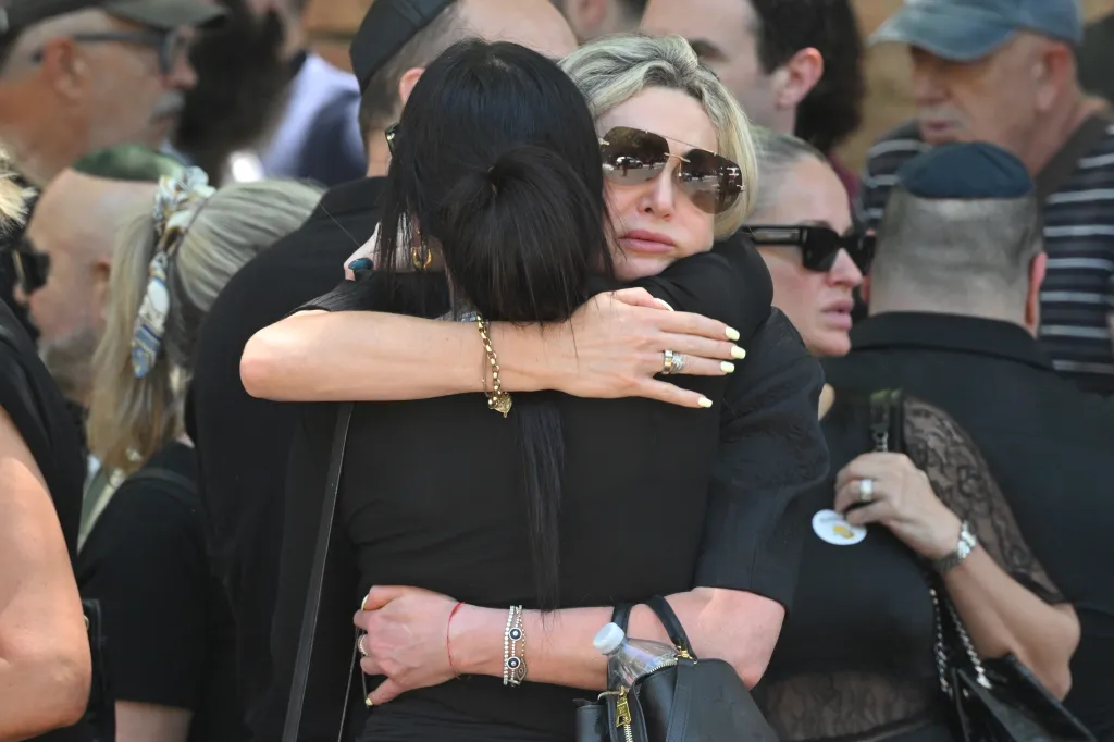 Mourners embrace after the funeral for 10-year-old Matilda