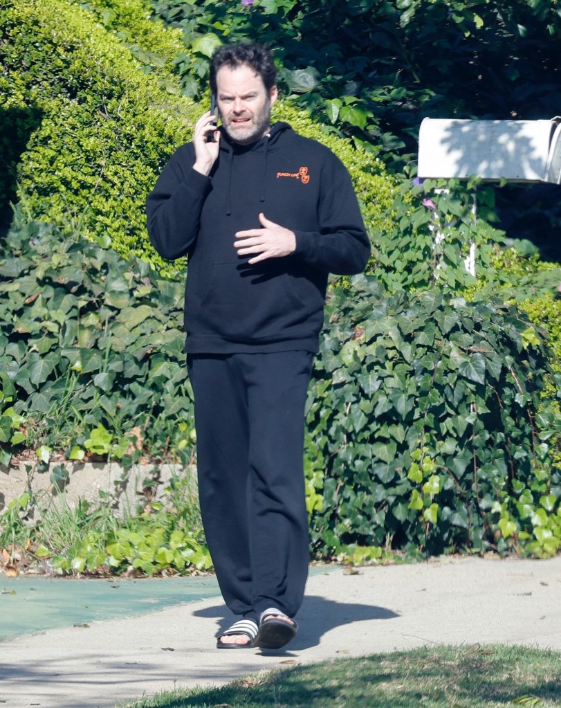 Bill Hader wearing a black hoodie and sweatpants while on a phone call.