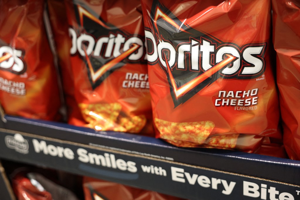 Bags of Nacho Cheese Doritos on a shelf.